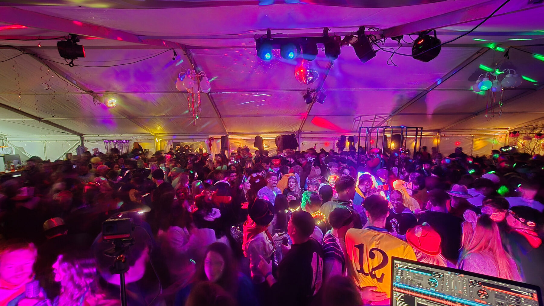 Volle Tanzfläche bei einem farbig beleuchteten Event